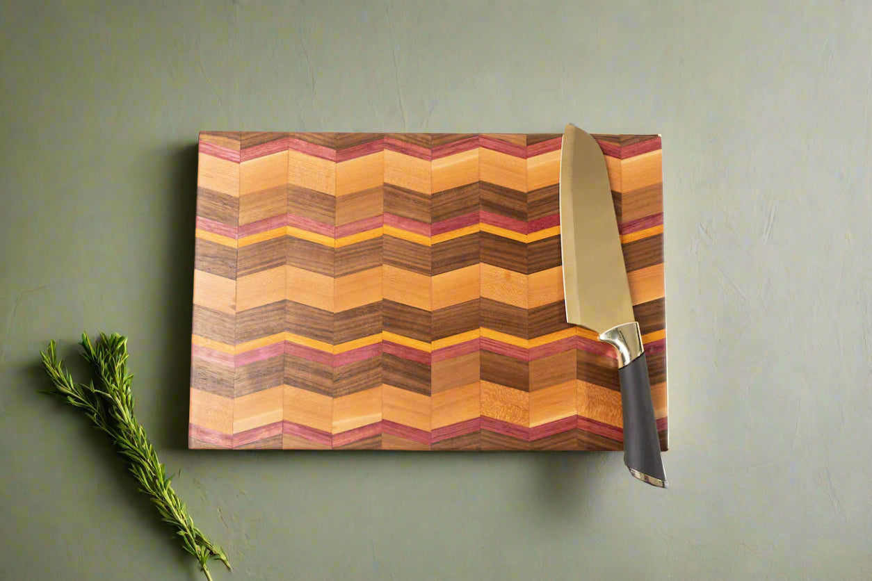 Introducing our handcrafted Chevron cutting board, a stunning addition to your kitchen. Made from Paduak, Walnut, Mahogany and Yellow Heart wood, this spacious and sturdy board is not only unique, but also expertly crafted for an elegant touch. Elevate your cooking experience with this timeless piece.